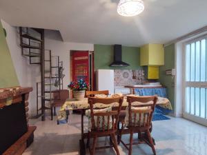 a dining room with a table and chairs and a kitchen at Casa Armania in Colle Micotti