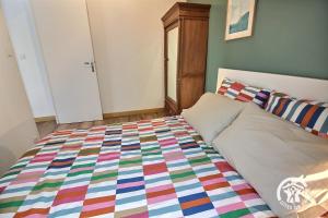 a bedroom with a bed with a colorful quilt at Aupres de mon arbre in Saint-Brieuc