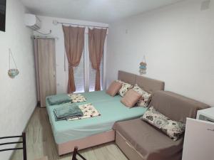 a small room with a bed and a couch at APARTMANI MARIJA in Čanj