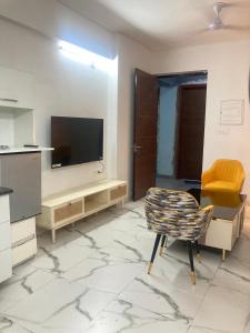 a living room with a television and a chair at Fully Furnished Flat WTC 106 in Gurgaon