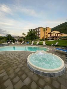 a large swimming pool with a fountain in the middle at VILLA IZZO B&B in Bagnoli