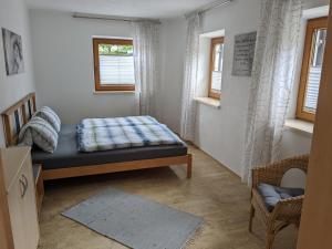 a bedroom with a bed and two windows at Gästehaus Kleisner in Innsbruck