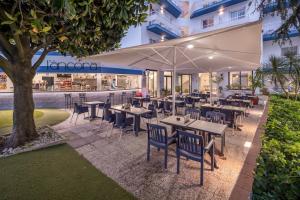 a restaurant with tables and chairs in front of a building at GHT Balmes, Hotel-Aparthotel&SPLASH in Calella