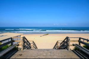 a wooden boardwalk leading to a beach with the ocean at Mobile home à Mimizan in Mimizan