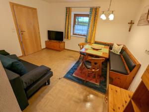 a living room with a couch and a table and a television at Gästehaus Kleisner in Innsbruck