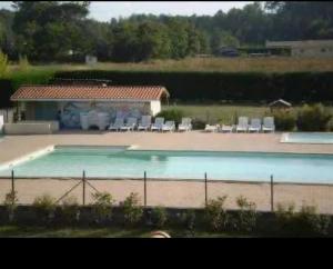 a large swimming pool with chairs and a house at Mobile home à Mimizan in Mimizan