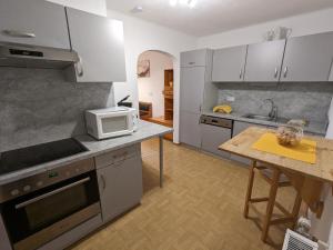 a kitchen with white cabinets and a table with a microwave at Gästehaus Kleisner in Innsbruck