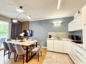 a kitchen and dining room with a table and chairs at Uniwersytecki by Rentoom in Toruń