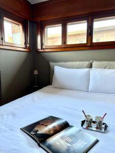 een slaapkamer met een bed met een boek erop bij La Mansardina in Parma