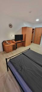 a bedroom with a bed and a desk with a computer at Pension Wolf in Gersdorf +13 photos