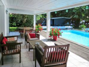 eine Terrasse mit Tisch und Stühlen neben einem Swimmingpool in der Unterkunft Villa Katy avec piscine, meublé de tourisme 3 étoiles in Andernos-les-Bains + 6 Fotos