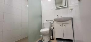 a white bathroom with a toilet and a sink at Pension Wolf in Gersdorf