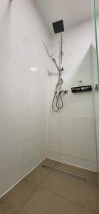 a shower in a room with white walls at Pension Wolf in Gersdorf