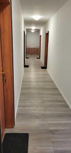 an empty hallway with wooden doors and tile floors at Pension Wolf in Gersdorf +12 photos