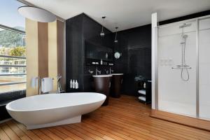 a bathroom with a large white tub and a shower at Le Méridien Beach Plaza in Monte Carlo