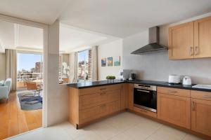 a kitchen with wooden cabinets and a view of a city at Le Méridien Beach Plaza in Monte Carlo