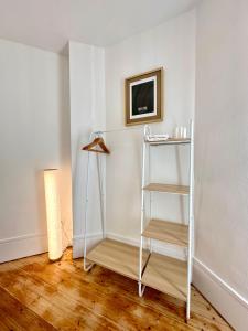 a shelf in a room with a white wall at La Villa Convivium - Chambres privées in Rouen