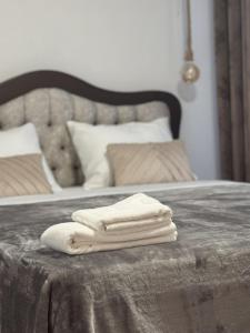 a pile of towels sitting on top of a bed at Apartman Booem in Bihać