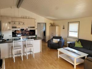 a kitchen and living room with a couch and a table at Kinderfreundliches 6 Personen Ferienhaus mit zwei Duschen und Toiletten, Sauna, Whirlpool und einem Wintergarten mit Kaminofen in Otterndorf in Otterndorf