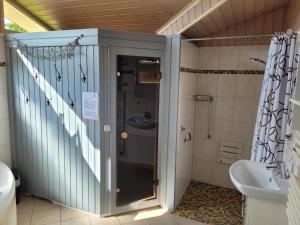 a bathroom with a shower and a sink at Kinderfreundliches 6 Personen Ferienhaus mit zwei Duschen und Toiletten, Sauna, Whirlpool und einem Wintergarten mit Kaminofen in Otterndorf in Otterndorf +28 photos