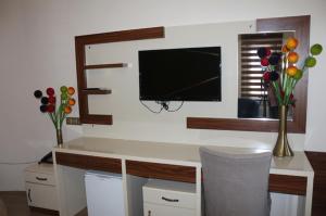 een kamer met een bureau, een tv en bloemen bij Mesnevi Hotel in Konya