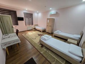 a hospital room with two beds and a table at Donish Hotel in Bukhara +38 photos
