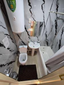 a bathroom with a toilet and a sink and a tub at Donish Hotel in Bukhara