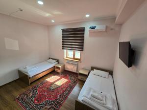 a small room with a bed and a tv at Donish Hotel in Bukhara