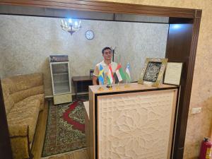 a man standing behind a podium in a room at Donish Hotel in Bukhara