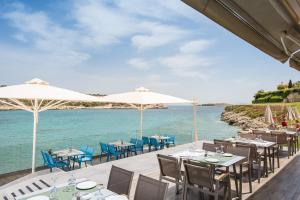マラティにあるMare Nostrum Villasの海とテーブルと椅子が備わるレストラン