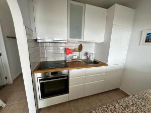 a small kitchen with white cabinets and a sink at Roca Negra in Puerto del Carmen
