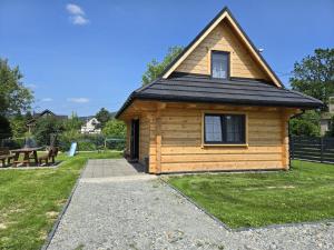 a wooden cabin with a black roof and a picnic table at Wilkowiana in Wilkowice