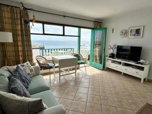 a living room with a couch and a view of the ocean at Roca Negra in Puerto del Carmen