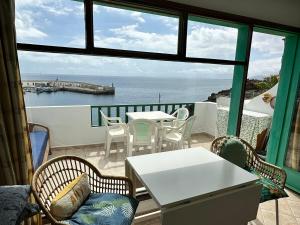 a balcony with a table and chairs and a view of the ocean at Roca Negra in Puerto del Carmen +7 photos