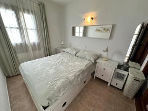 a small bedroom with a bed and a mirror at Roca Negra in Puerto del Carmen