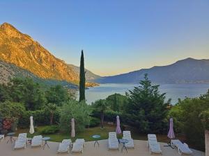a group of chairs and umbrellas next to a lake at Green Village studio in Gornji Orahovac