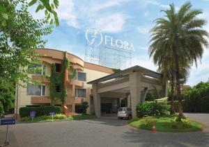 a hotel with a palm tree in front of a building at Flora Airport Hotel and Convention Centre Kochi in Nedumbassery