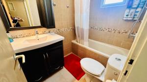 a bathroom with a toilet and a sink and a tub at Raanana Luxury Apartments in Ra‘ananna +12 photos