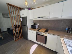 a kitchen with white cabinets and a stove top oven at ONLY4VIEW Beach Front in Sainte-Anne