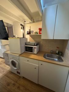 a small kitchen with a sink and a microwave at Duplex Studio 3 minute drive from Luton airport in Luton