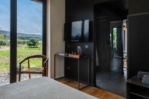 a bedroom with a bed and a tv on a wall at Scorzamara Country Lodges in Villasmundo