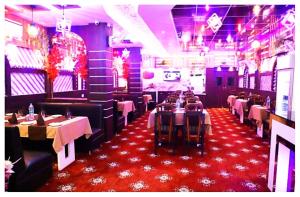 a dining room with tables and chairs in a restaurant at Hotel Janvi International Inn Muzaffarpur With Best Facility And AC OR NON AC Both Room in Muzaffarpur