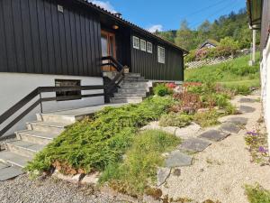 a house with stairs leading up to a building at Hus med stor hage ved Vatsfjorden in Åmsosen
