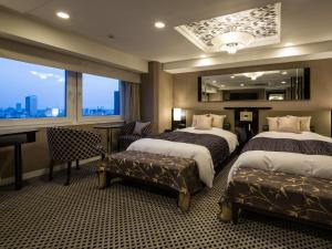 a hotel room with two beds and a desk and a window at APA Hotel & Resort Nishishinjuku-Gochome-Eki Tower in Tokyo