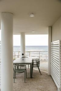 a dining room with a table and chairs and the ocean at MAREKI60 - Il Paradisino Beach Club in San Vincenzo