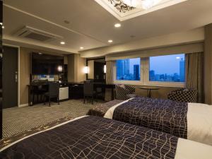 a hotel room with two beds and a desk at APA Hotel & Resort Nishishinjuku-Gochome-Eki Tower in Tokyo