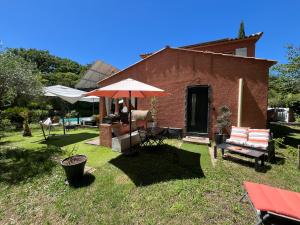 a house with an umbrella and a table and chairs at Studio indépendant avec hammam in Montpellier