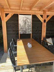a wooden table and chairs on a wooden deck at Casa Elixa prachtige stacaravan met heerlijke overkapping in Eext +16 photos