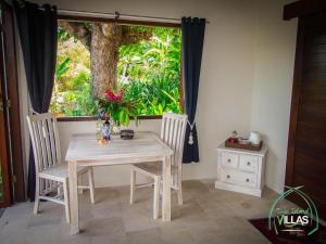 une table et des chaises dans une pièce avec une fenêtre dans l'établissement Twin Island Villas & Dive Resort, à Nusa Lembongan