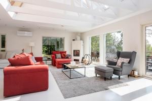 una sala de estar con muebles y ventanas de color rojo. en Stay North - Merimaa, 